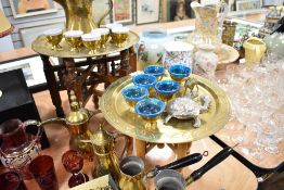A Persian brass Dallah coffee pot and two smaller examples, two small eastern brass tray-topped
