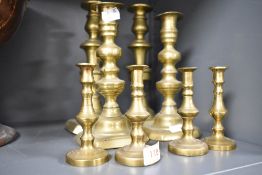 Four pairs of brass candlesticks