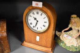An Edwardian inlaid-mahogany mantel clock, of arched form, with Roman hours to the enamelled dial
