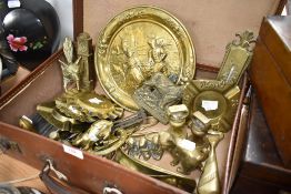 A vintage brown card suitcase containing a selection of miscellaneous brasswares, including fox mask