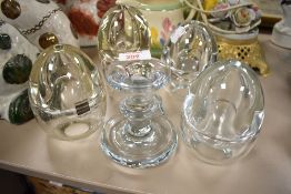 Four glass paraffin burners and a candle stick.