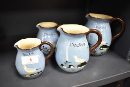 A group of four graduated Torquay ware jugs, named 'Dawlish' and decorated with birds