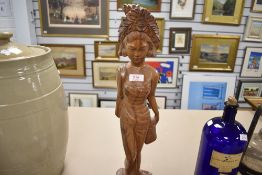 A Burmese carved-hardwood figure of a female in native attire and headdress