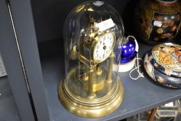 A Vintage brass anniversary clock having enamel face and glass dome.