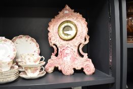 A Victorian puce pottery mantel clock, rocaille-moulded with painted chrysanthemums