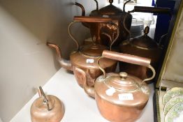 A collection of copper kettles of varying size.