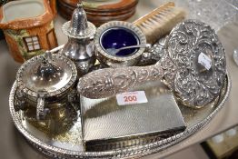 An early 20th century plated dressing table trio comprising of brushes and mirror, a condiment set,
