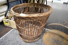 A vintage woven-wicker waste paper basket