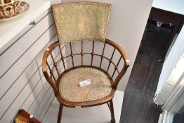 An Arts & Crafts ash and beech tub-form armchair, having raised and padded back over spindle and