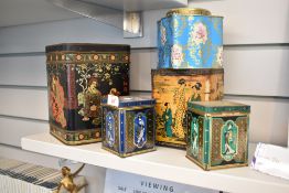 A group of decorative tin tea canisters, oriental themed designs
