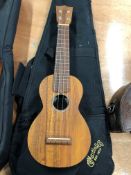 A Martin soprano ukulele , model OXK, with padded gig bag