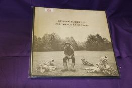 A copy of All Things Must Pass by George Harrison in VG - no poster / three albums and inners