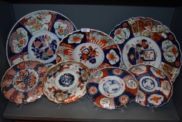An impressive collection of Japanese porcelain scalloped Imari design plates,chargers and dishes