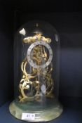 A Skeleton clock in glass dome, marked Thwaites and reed.