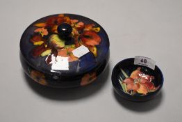 A small Moorcroft deep blue ground pin dish and a similar lidded bowl being damaged