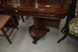 An early 19th Century mahogany fold over games table having brass detailed inlay on central