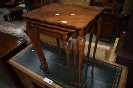 A mid 20th Century walnut nest of three tables on cabriole legs