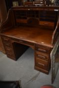 An early 20th Century mahogany roll top desk, with some interested features including fold out