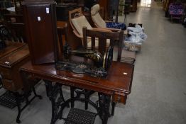 A Victorian treadle sewing machine having cast base and mahogany case