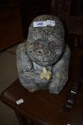 A concrete garden ornment modelled as a happy gorilla