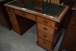 A Victorian Aesthetic style golden oak pedestal desk, possibly later green leather skiver top