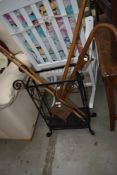 A vintage wrought iron stick stand and contents