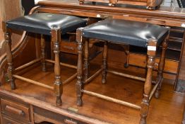 Two vintage oak framed and leather footstools