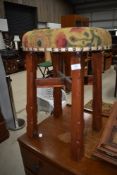 A traditional stool having upholstered seat and adzed frame
