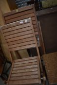 A pair of folding teak garden chairs