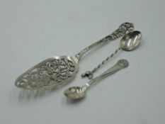 A white metal cake slice bearing marks having extensive moulded decoration, a Danish silver teaspoon