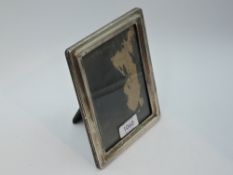 A silver photograph frame of rectangular form having wooden easel stand, Birmingham 1922, makers