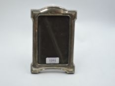 A silver photograph frame of Art Nouveau form having arched top and wooden easel stand, Birmingham
