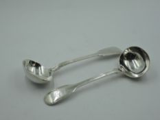 A pair of Victorian silver sauce ladles in the fiddle and thread pattern, bearing (worn) monogram to