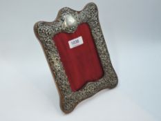 A Victorian silver photograph frame having pierced scroll and foliate overlaid decoration with