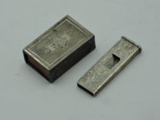 An HM silver match box case having engine turned decoration and monogrammed cartouche, and a white