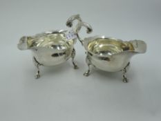 A pair of Edwardian silver sauce boats of traditional form having trefoil hoof feet, loop handles