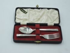 A cased child's silver first spoon and fork having moulded stems with plain cartouche, Sheffield