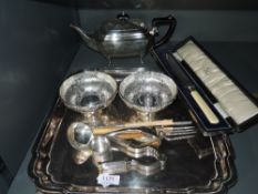 A selection of silver plate including square tray with raised rim and hoof feet, teapot, bowls, cake