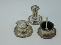 A three piece silver cruet set having flared and shaped bases, blue glass liner (one missing),