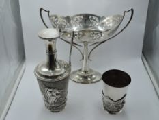 Three pieces of silver plate including a tall table basket, lidded wine ewer having bacchanalian