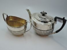 A silver teapot and sugar bowl having gadrooned decoration and architectural handles, Sheffield