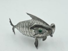 A Spanish silver articulated fish pepperette having green cabochon eyes and screw fin opening,
