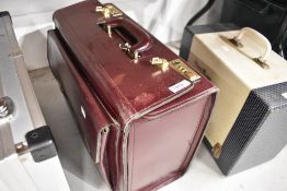 A burgundy leather suit or similar case