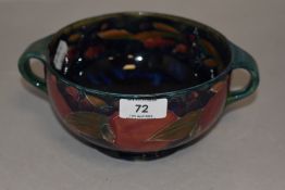 A Moorcroft twin handled bowl,circa 1930, having dark blue ground and tube lined pomegranate and