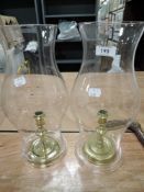 A pair of brass candle sticks marked CW Raleigh with large glass chimney funnels