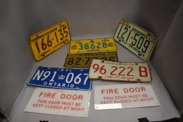 A mixed lot of foreign tin registration plates and two fire door signs.