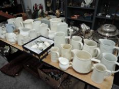 A selection of various water milk and cream jugs mostly with white glazes