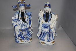 A pair of modern Chinese blue and white figures, depicting scholars, each enriched in gilt.