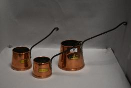 Three antique copper and brass cider measures.
