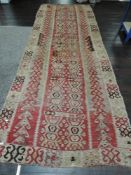 An Afghan Kilim rug, decorated with rows of repeating designs, some damage, appears to be antique.